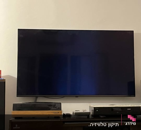 טלוויזיה שטוחה על קיר עם ציוד אודיו ווידאו